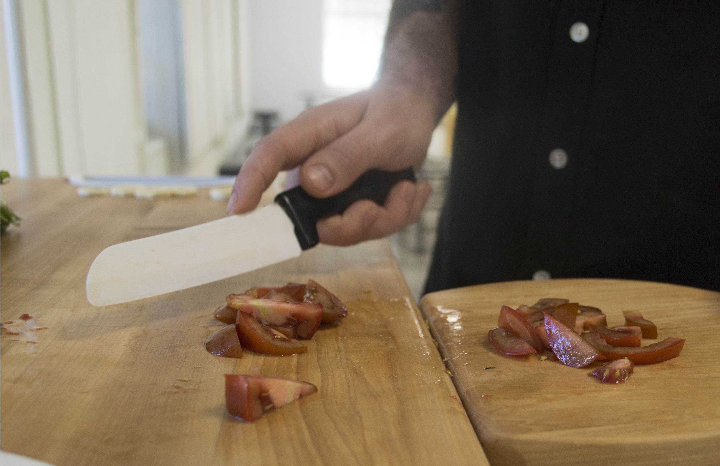 Chopping vegetables and putting them on the small cutting board. 