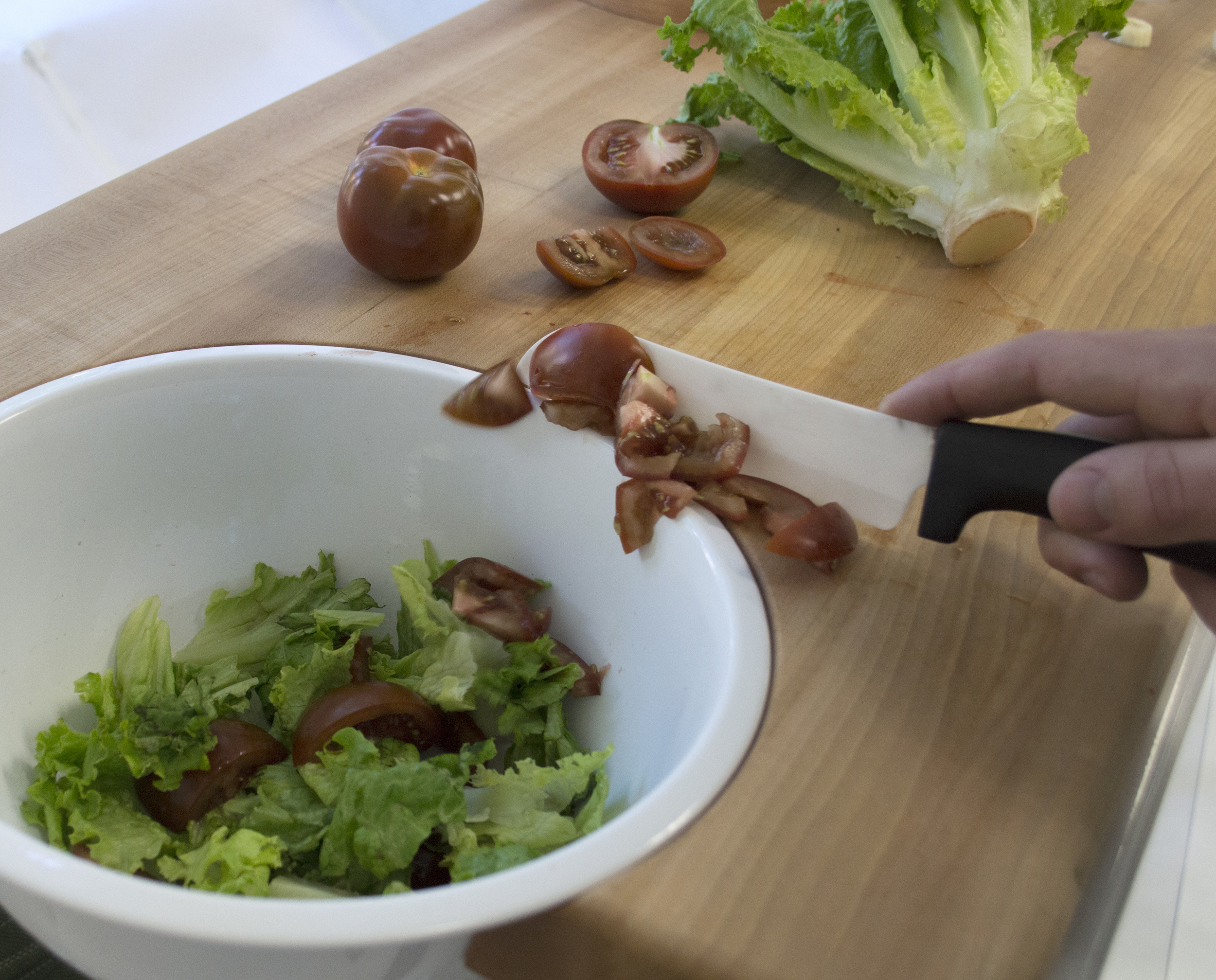 Chopping vegetables and sliding them into the removable bowl.