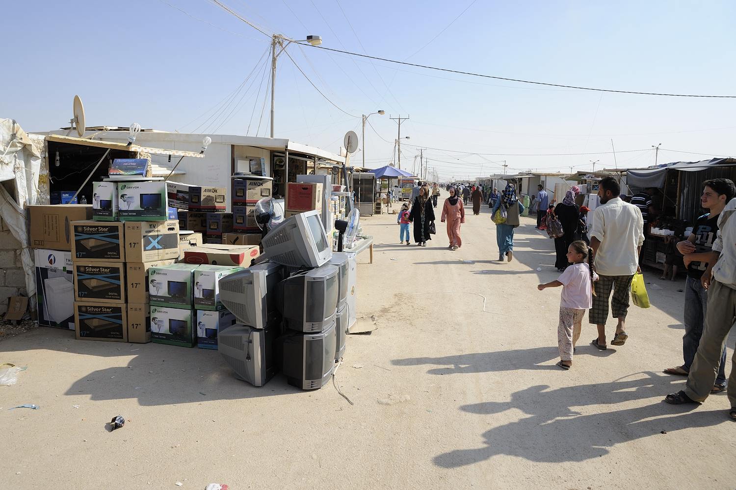  Things go fast in Zaatari refugee camp. When the camp opened a little over 1,5 years ago people were completely dependent on aid. Now there is an estimated 3.000 shops in this huge camp, varying from this tv-store to the mother of a family selling s