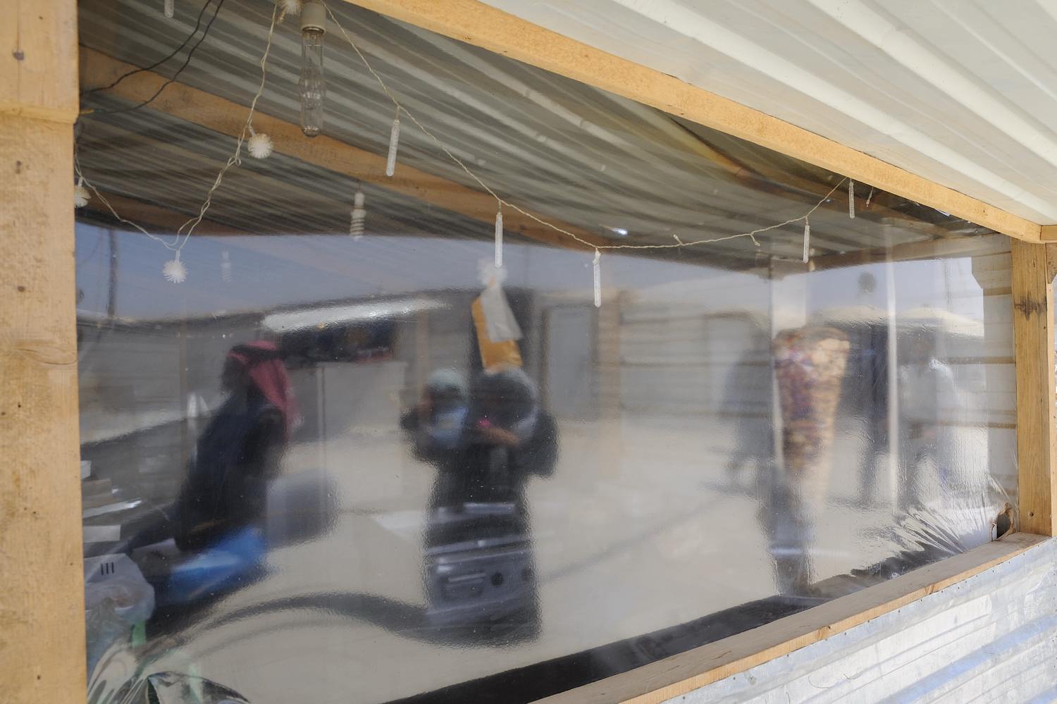  Business are thriving in Zaatari's main street or 'Champs Elysees', and people use anything available to build their shops and restaurants.   Windows are hard to get, so this shawarma restaurant uses thick plastic instead.  