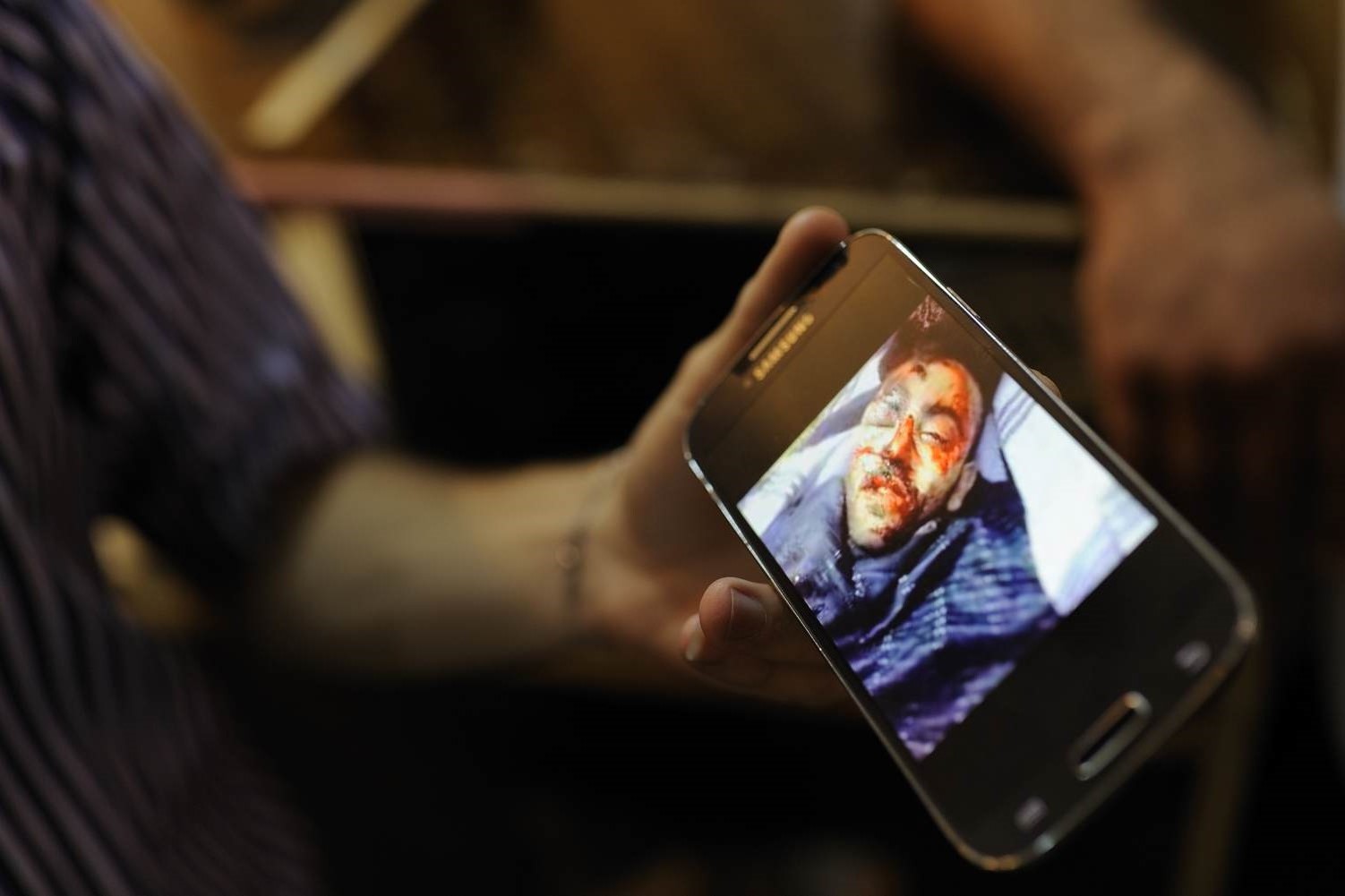  A shopowner in Za'atari refugee camp show an image of a friend who was killed in the war 