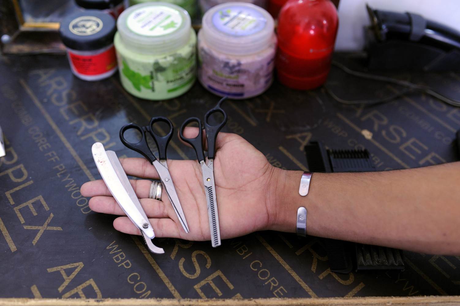  The owner of a barbershop shows the scissors and the razor he could take with him when he fled Syria. 