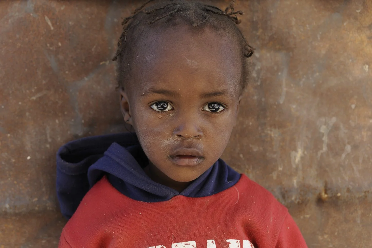 COA-by-Thijs-9 Jason Swartbooij (2) woont samen met zijn oma Theresia (43) en nog een paar kinderen in een eenvoudige hut in het droge en afgelegen zuiden van Namibië. De man van Theresia werkt op een boerderij in de buurt. Ik ontdek het mooie en liefdevolle gezin toevallig als ik op zoek ben naar een zuidelijke toegang tot de Fish River Canyon. Een paar jaar later ben ik terug geweest naar deze plek om het gezin wat geld te geven om een eigen huis te bouwen. Voor zover ik heb kunnen nagaan is dat ook werkelijk gelukt, in een stadje niet ver van de plek waar ik ze ontmoette.