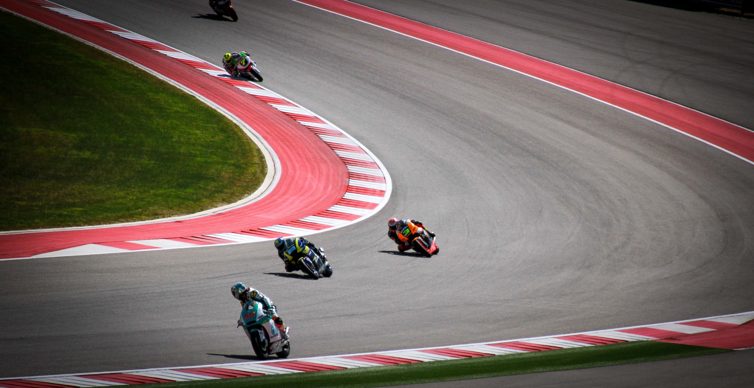  During a practice run, Moto2 rider number 55 looks at the other riders coming out of Turn 2 at the Circuit Of the Americas. 