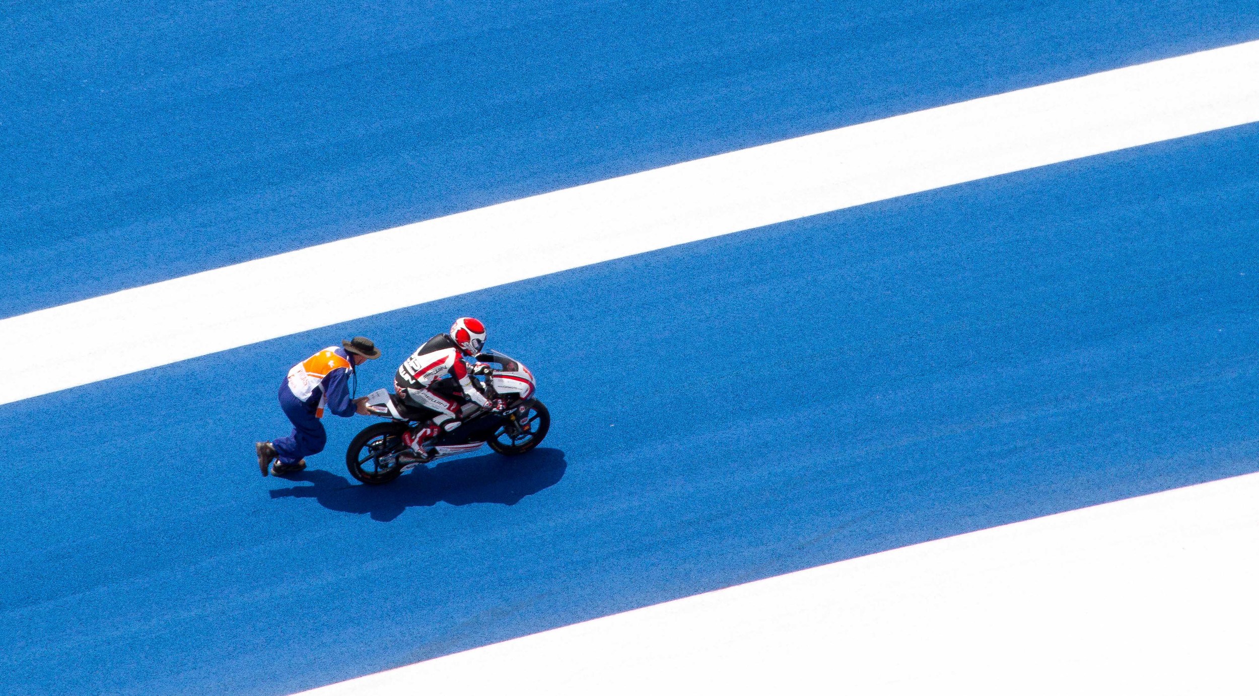  Looking down on Turn 18 one ride had some bike trouble.&nbsp;&nbsp; Here is another shot I captured from the Observation Tower of a track, where a corner worker is trying push start this bike. 