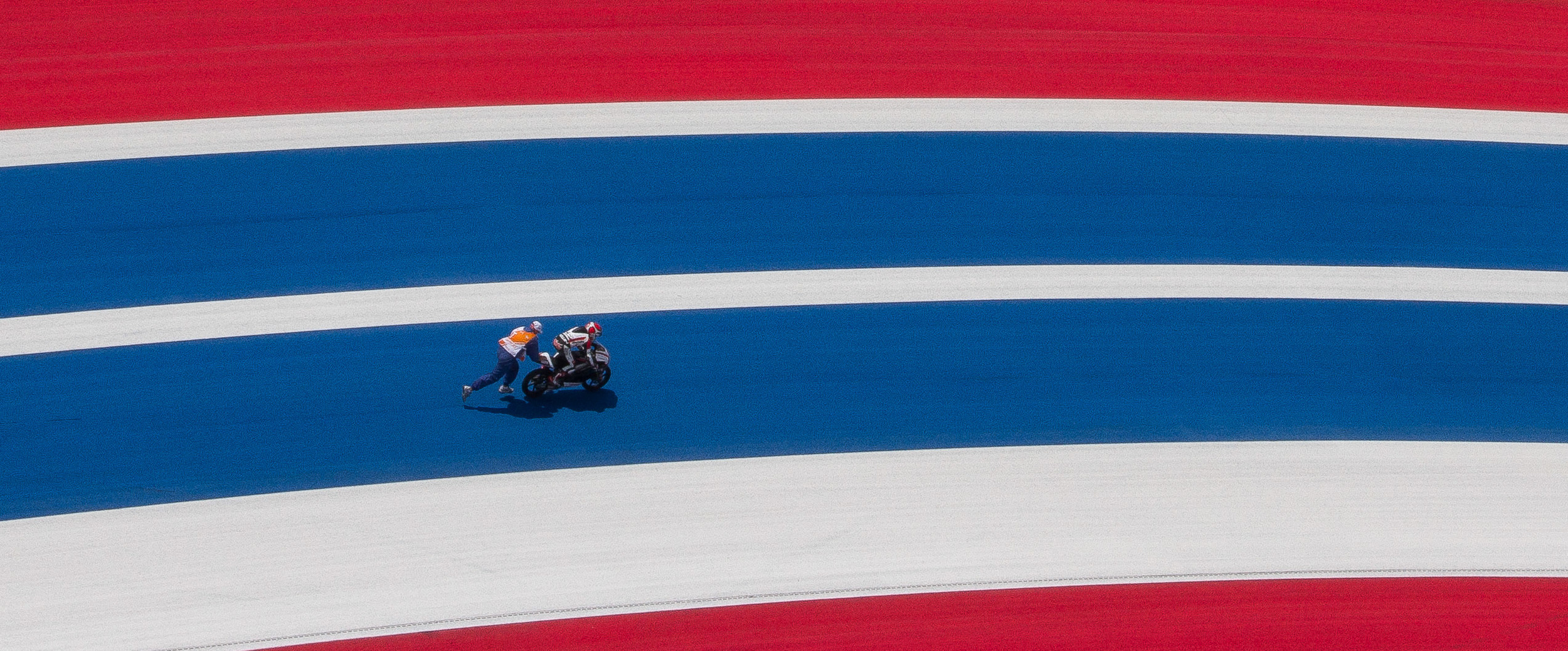  Looking down on Turn 18 one ride had some bike trouble.&nbsp;&nbsp; Here is another shot I captured from the Observation Tower of a track, where a corner worker is trying push start this bike. 