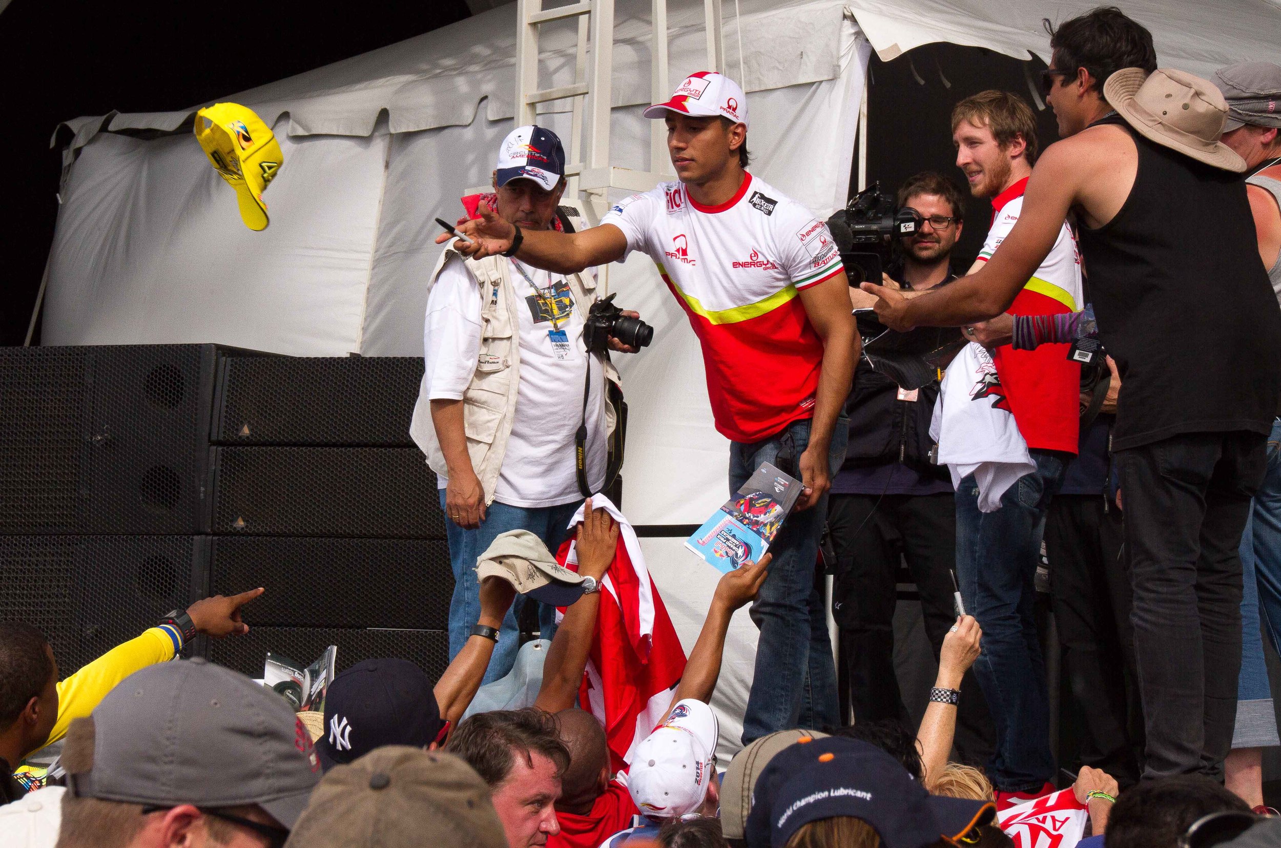  Columbian MotoGP rider Yonny Hernandez tosses a signed hat back to a fan at Circuit of the Americas riders Q&amp;A session. 