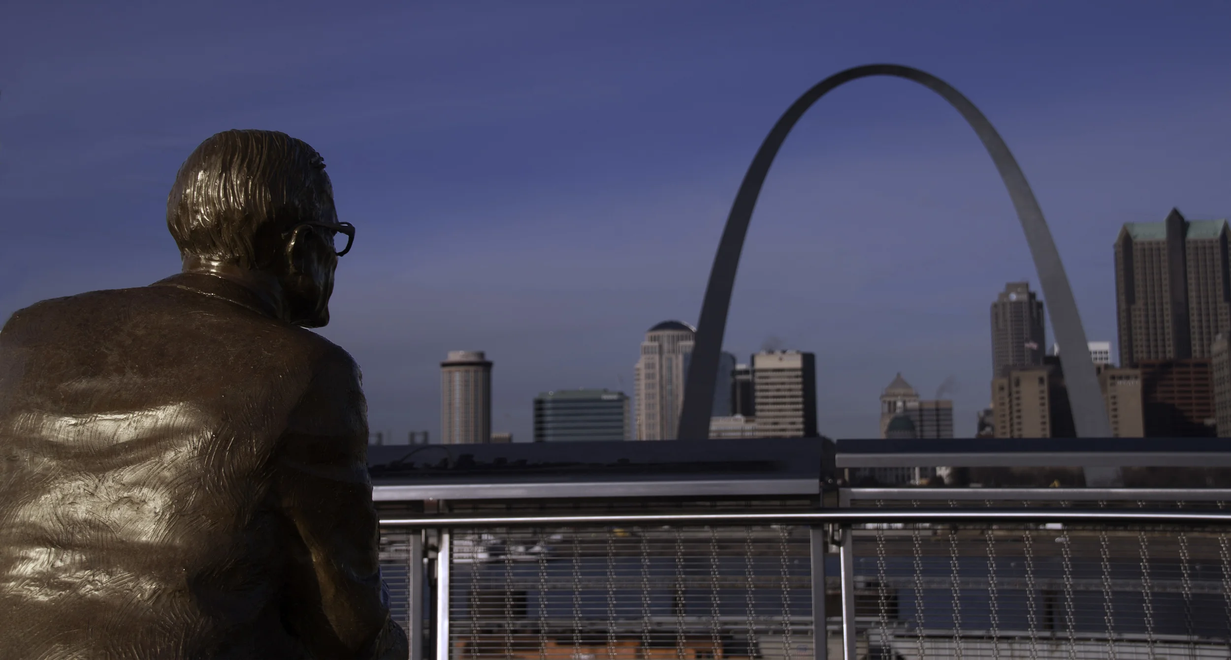 A shot behind the Malcom Martin Statue looking across the Mississippi River at the Gateway Arch