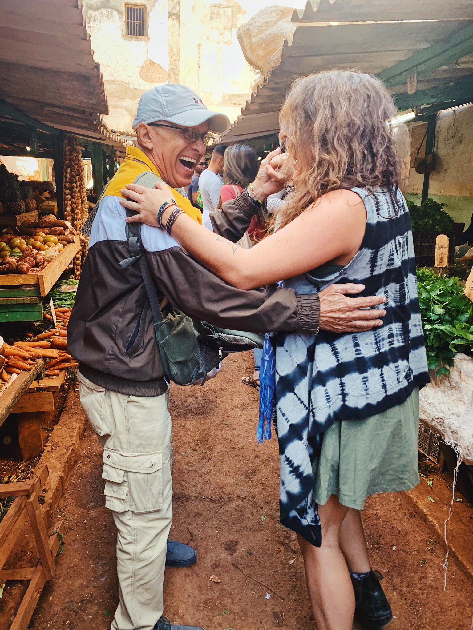 A friend is lead to spontaneously dance with a local man in the middle of a street market in Central Havana.