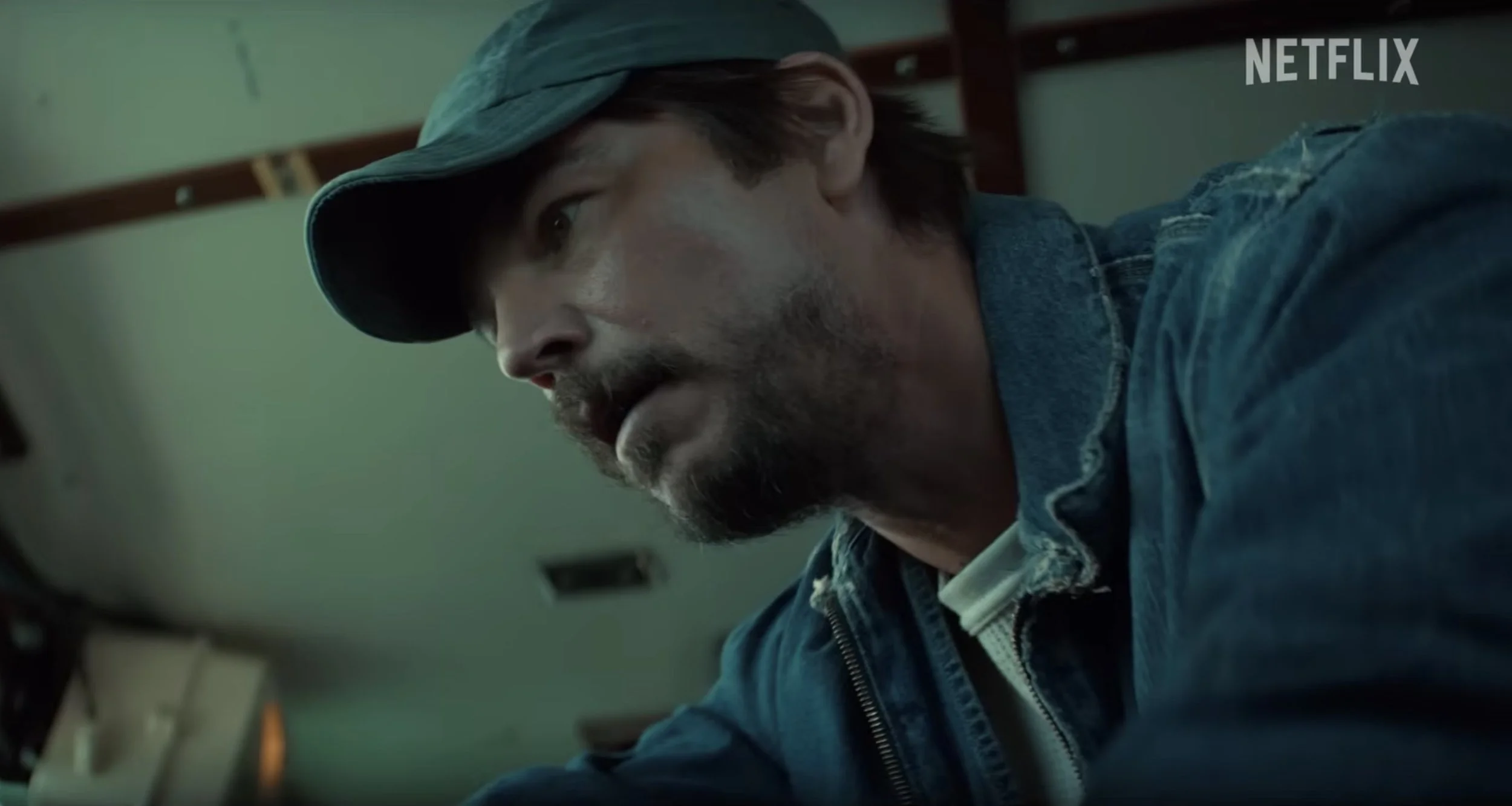 A shadowy close-up of Calvin in a boat cabin from the Below trailer