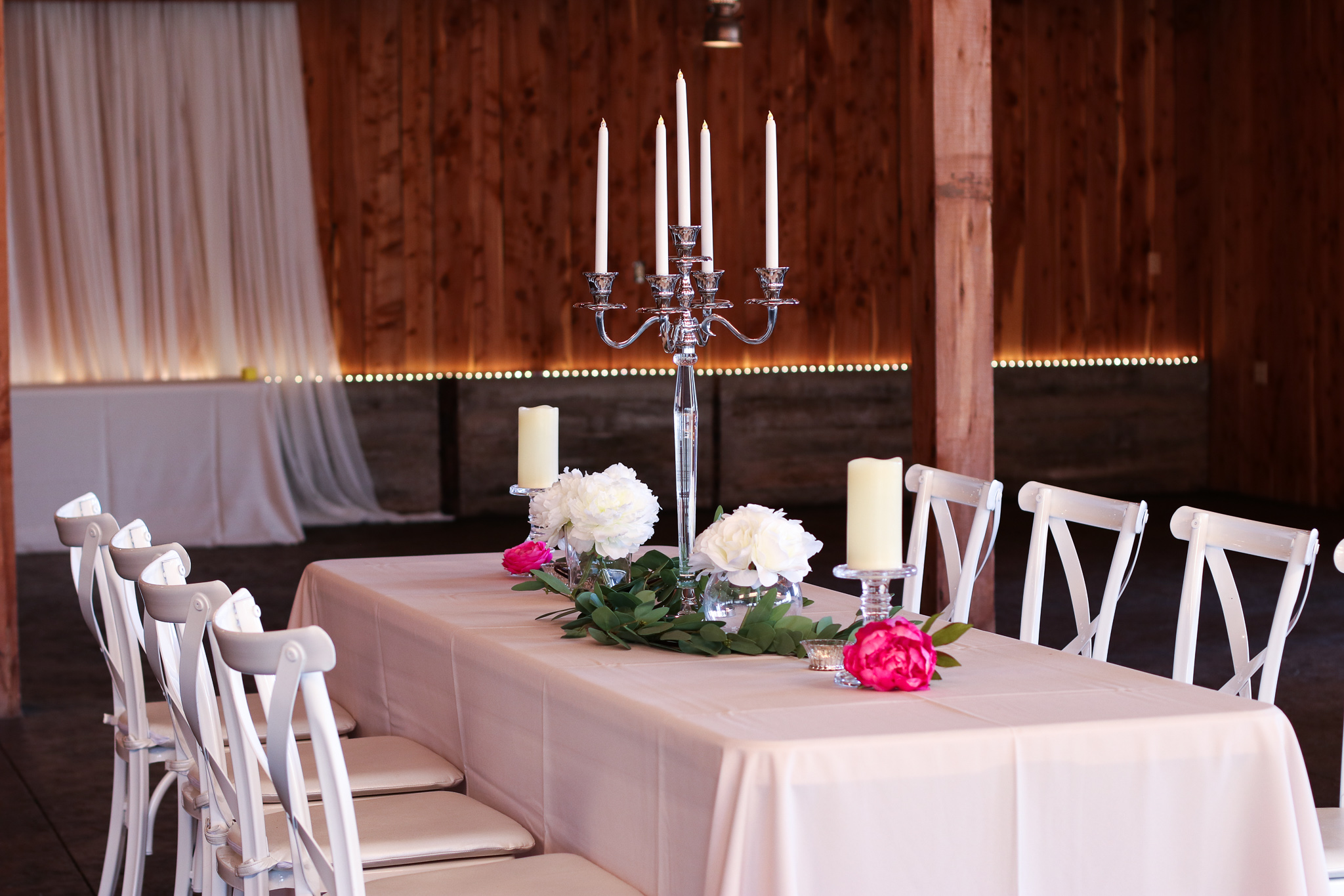 Up to 6 Straight Tables: Large candelabras, Green eucalyptus garland, Clear glass pillar candle holders (2) — Haue Valley: St. Louis Wedding Venues