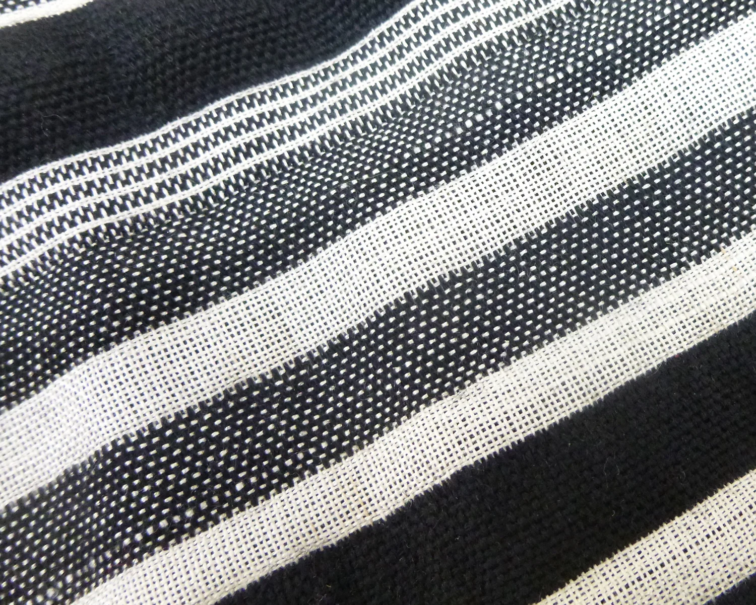Hand woven on Texel dobby loom using an alternating (end on end) warp of black wool and natural silk warp.