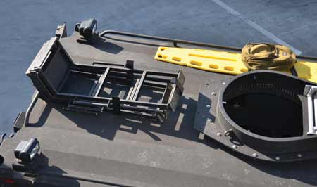 One steel bracket shaped like a “T” with three vertical prongs was welded to the roof. This allowed three mission ladders to be stacked on top of each other between the two lateral prongs, which limited side-to-side movement.