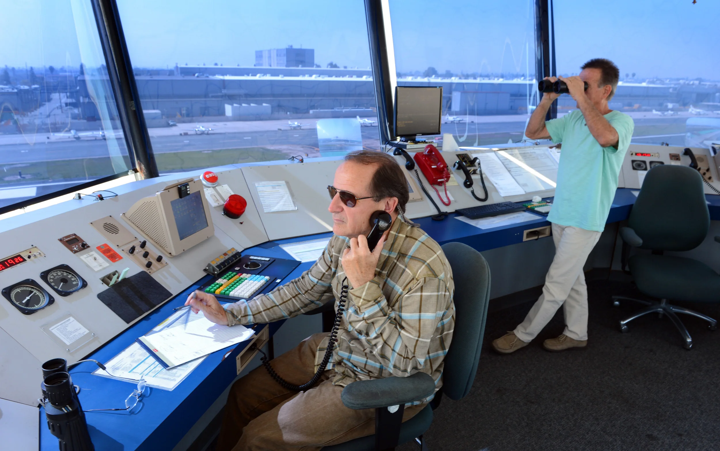 Air traffic controllers Tom Morris, left, and Derk Kuyper monitor activity at the Hawthorne Airport in this March 2013 photo. (Brad Graverson / Staff Photographer)