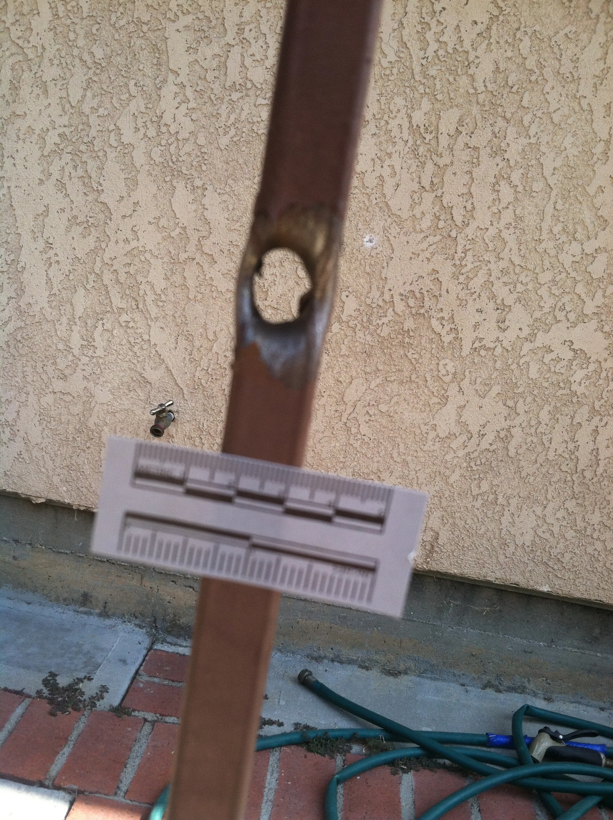 Bullet Hole in one-inch wide metal fence poll on Olive Street and 107th Street where DeAndre Jackson died..