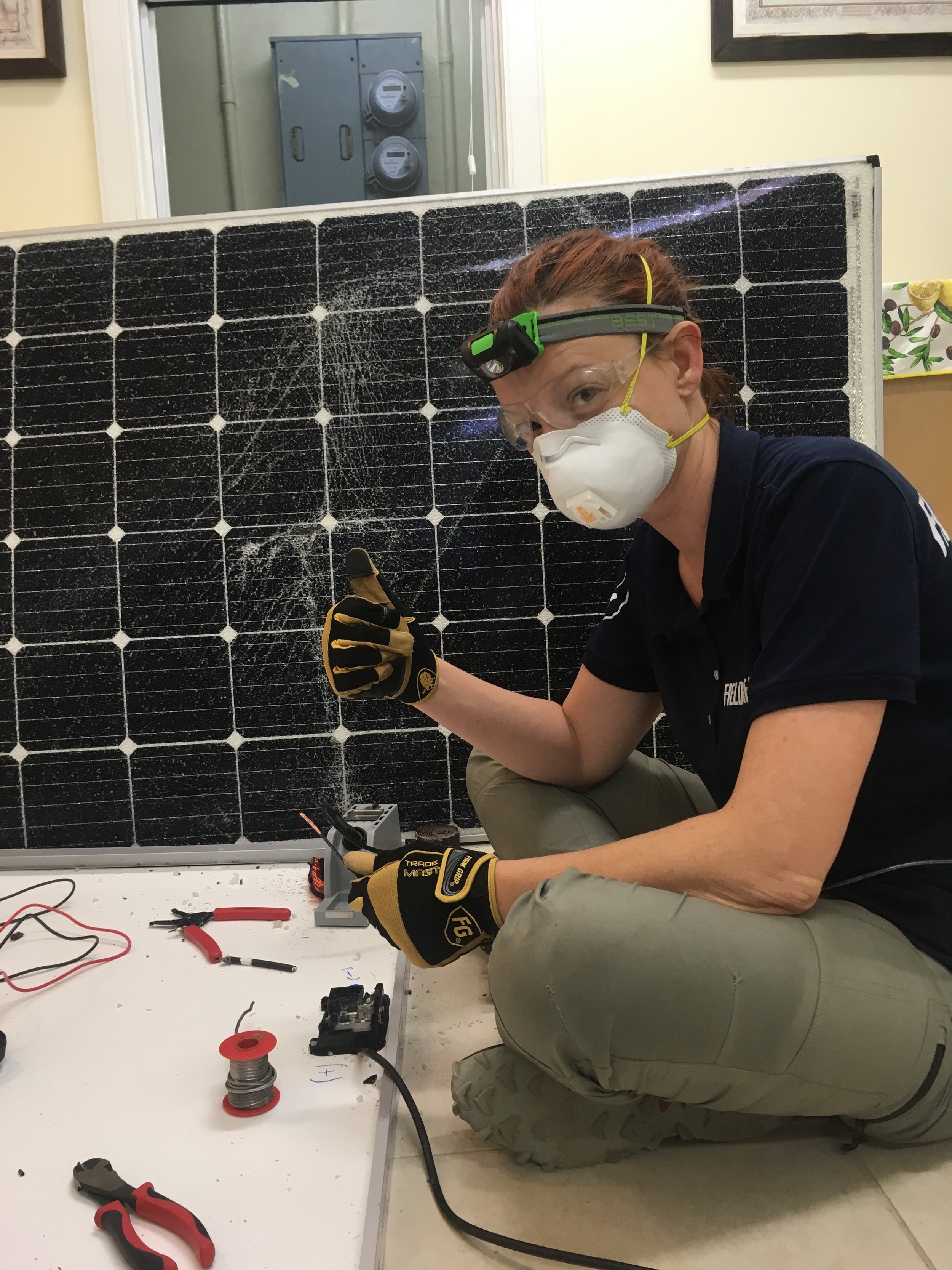 Dara soldering and reparing solar panels.JPG