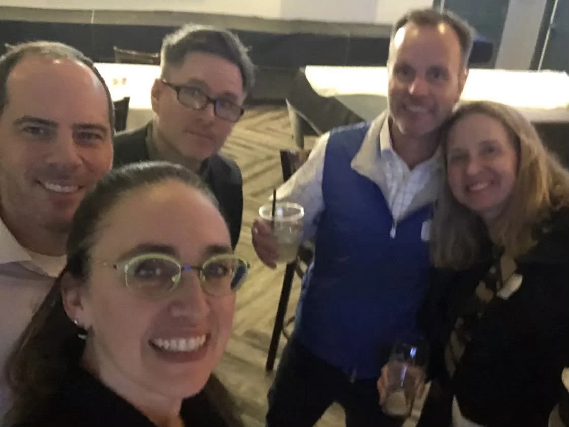 A photo of three men and two woman at a high school reunion