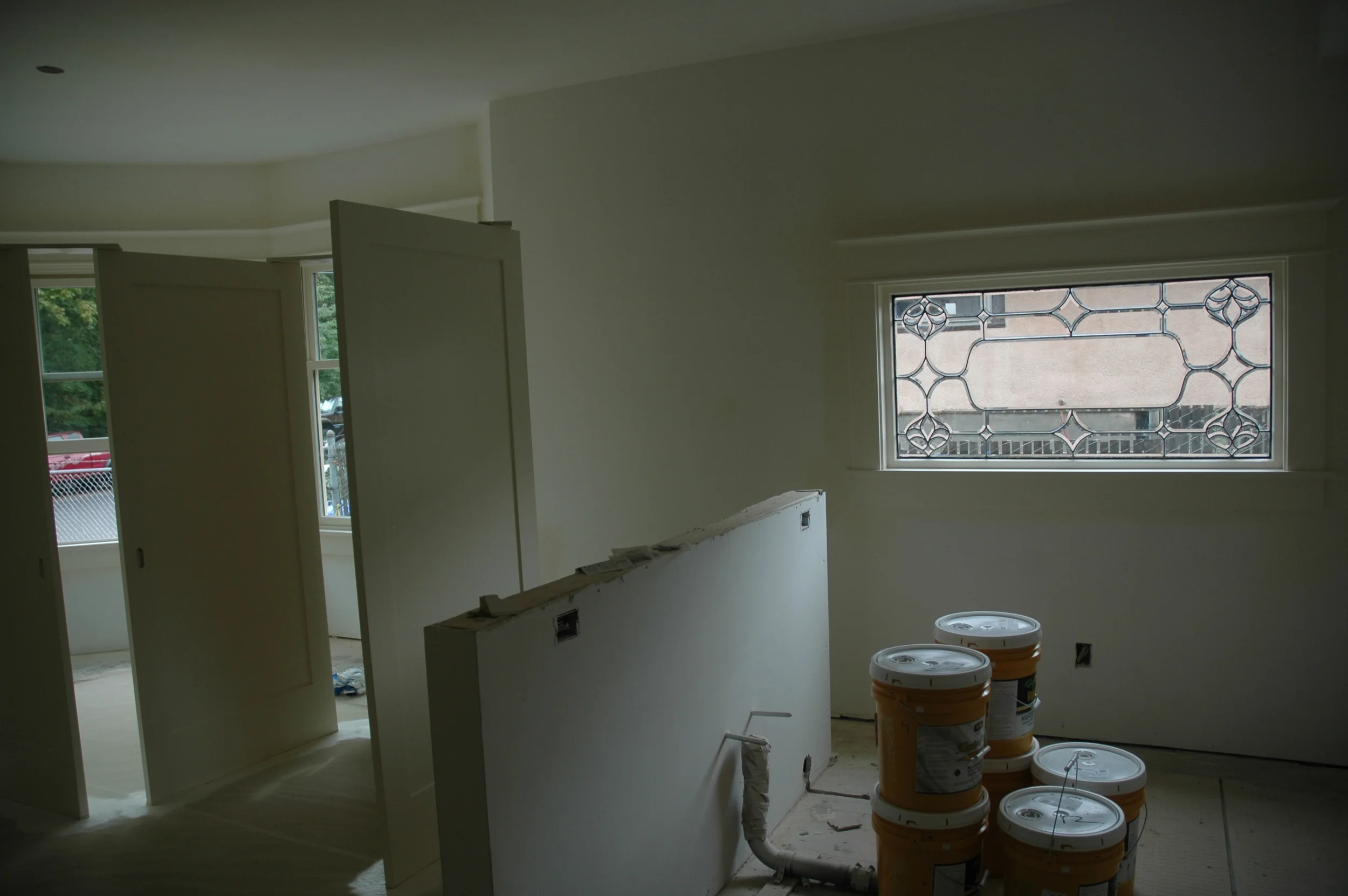 Gallons of paint in the Sellwood with one of the leaded glass windows