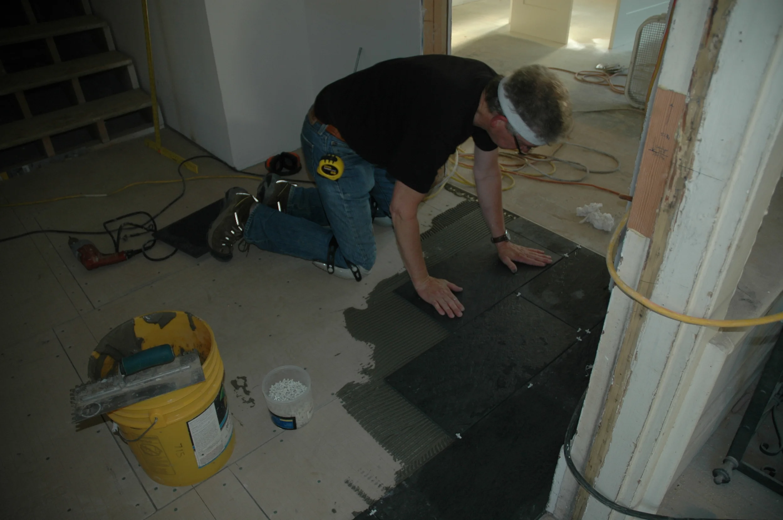 Jeff hurrying to place tile between regular crew shifts