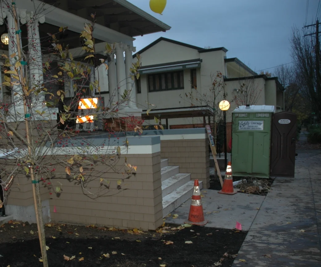 Green porta potty sculpture while people moved in