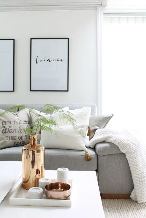 Tyylikäs yksinkertainen asetelma, jossa käytetty sisustuksen tehosteväriksi kuparia. Toistuu myös tyynyn tupsussa. Kuva: Pinterest