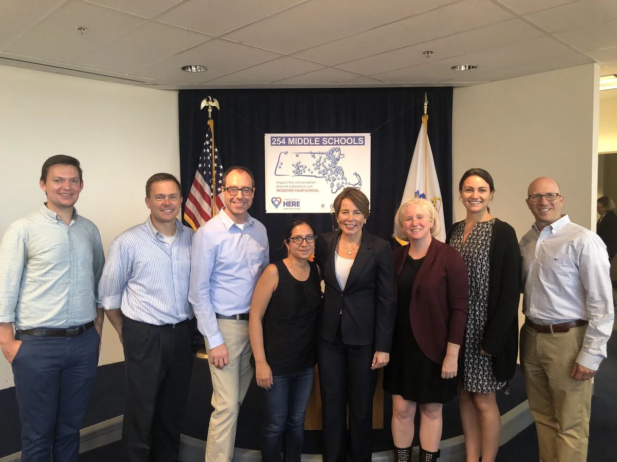 From left: Michael Fogarasi, Adam Landry, Peter Stidwill, Loren Lee-Flynn, Attorney General Maura Healy, Leigh Hallisey, Mikaela Johnson, Gary Goldberger