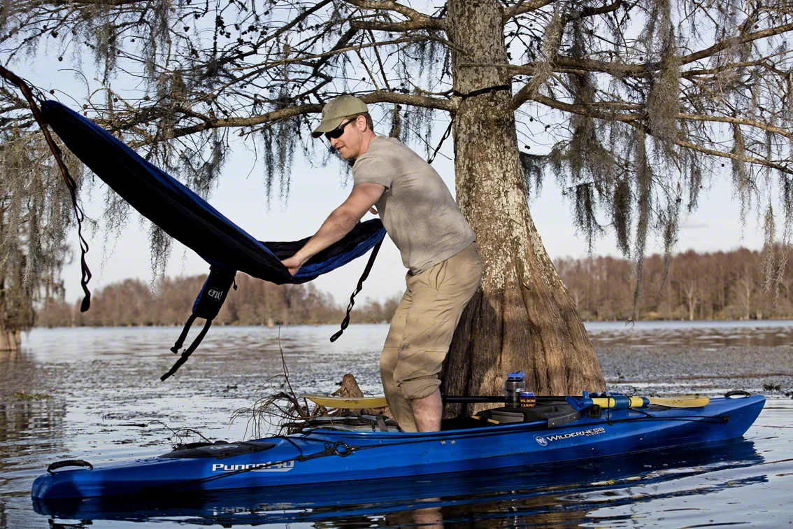 nate doing his best to climb into a hammock from a kayak