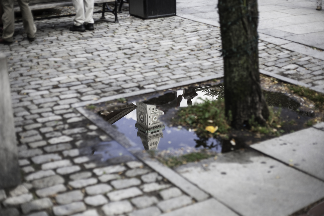 reflection of samuel adams and the custom house clock tower in bean town