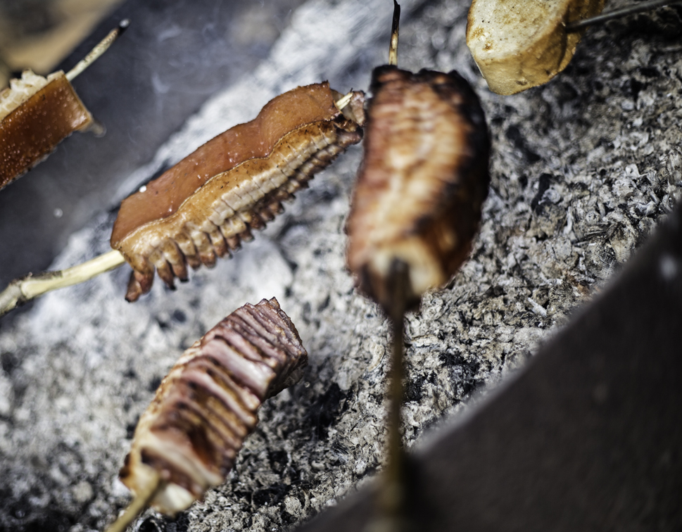slow roasting the pig over the coals