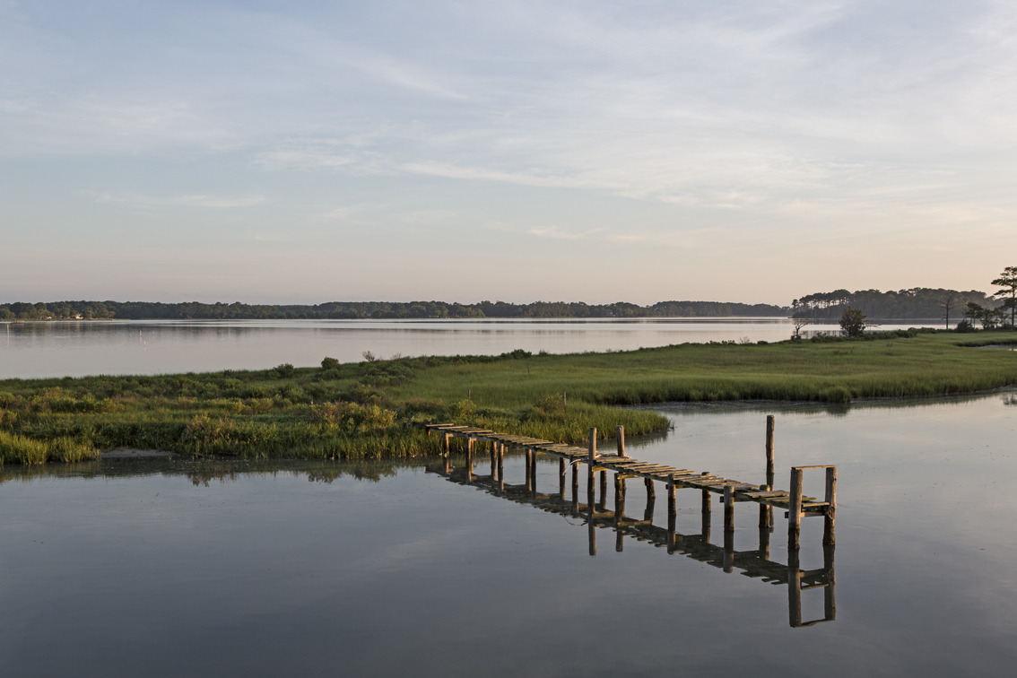 The morning view from the deck over glassy waters. I still have no idea what this dock was for, but it made for a good photo subject.