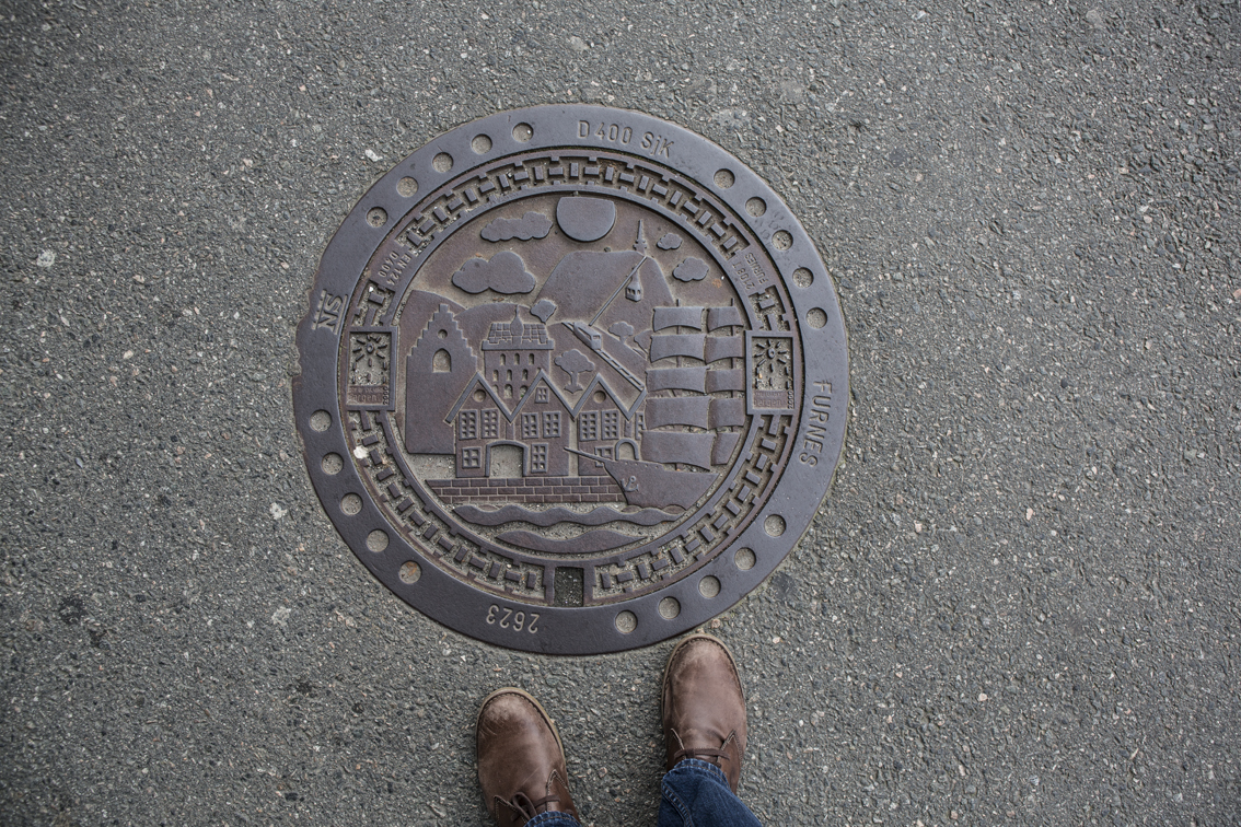 Norway has some of the best man-hole covers ever. I assume this is a scene of the Bryggen Harbor.