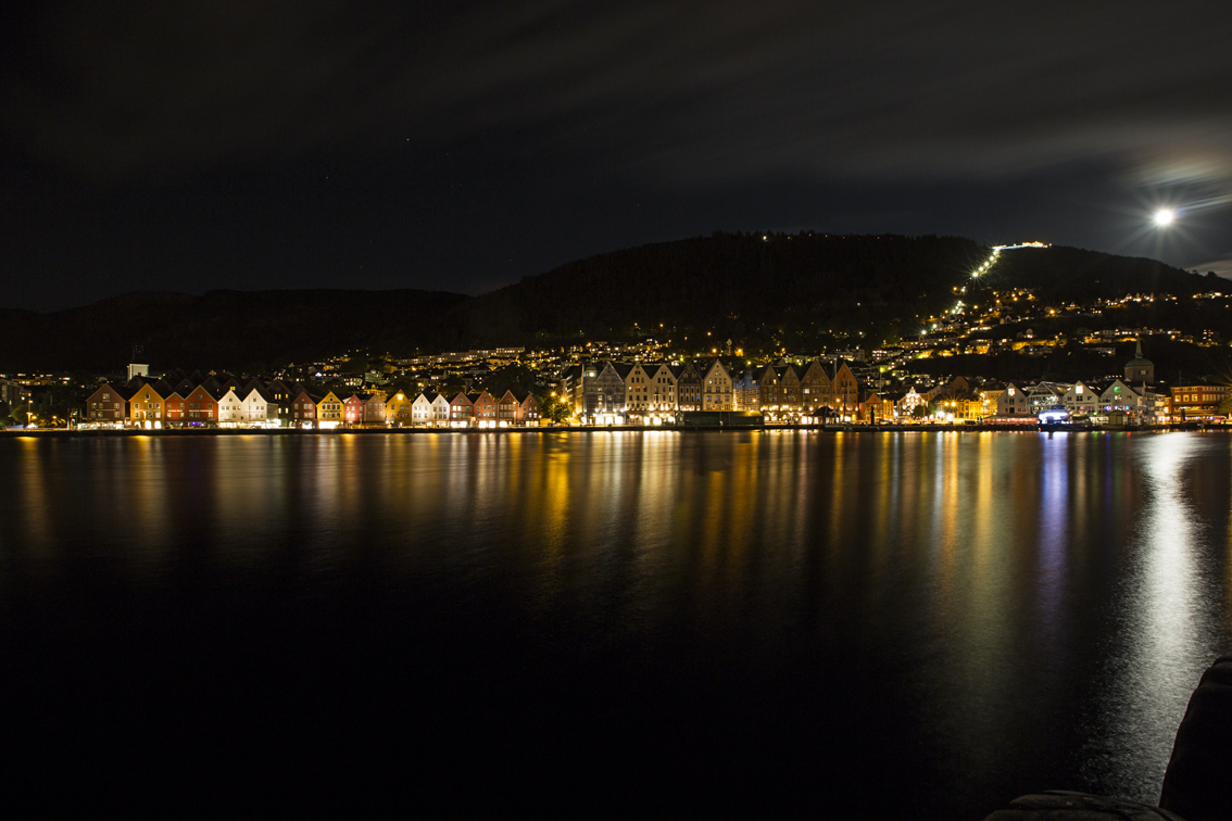 The neighborhood of Bryggen from across Bergen Harbor, with a full moon rising over Mt. Floyen. 