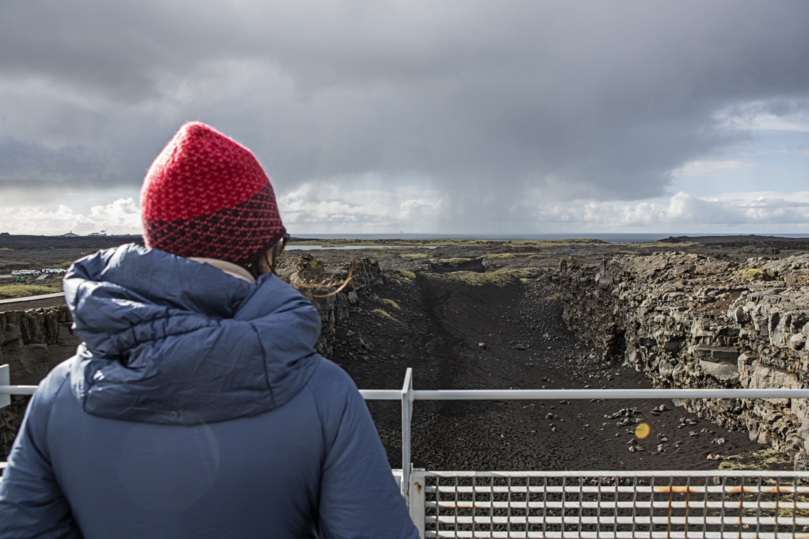 Sloane standing between the continental divide, some classic Iceland skies in the background.