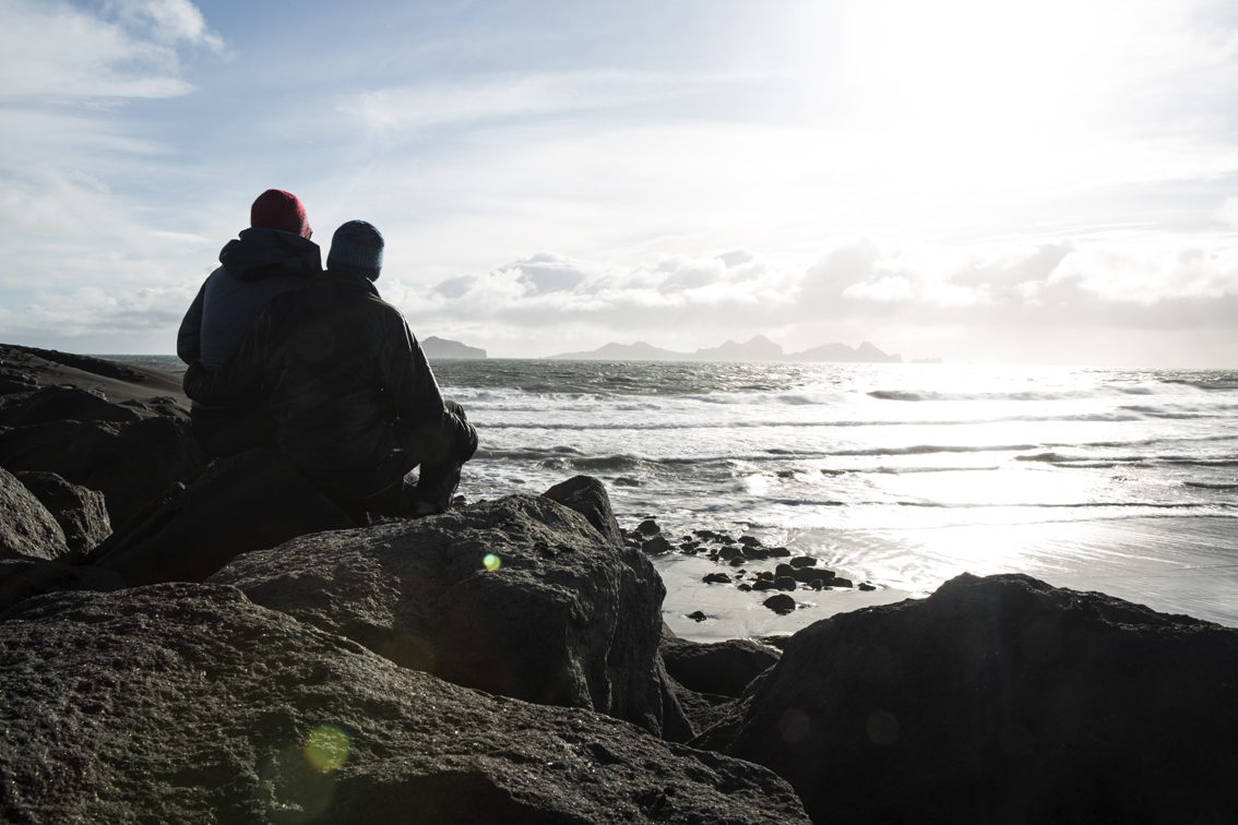 Sitting on the rocks at Landeyjahöfn harbor, in the distance is Vestmannaeyjar, a group of inhabited volcanic islands.
