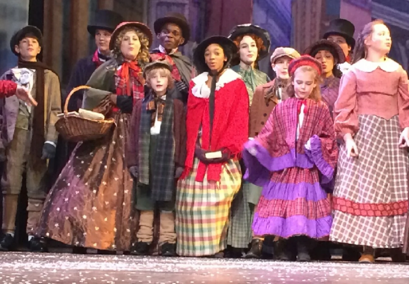  Claudia-Ruthie (pictured center in red shawl) is in the evening viewing of A Christmas Carol . The last performance is December 23!