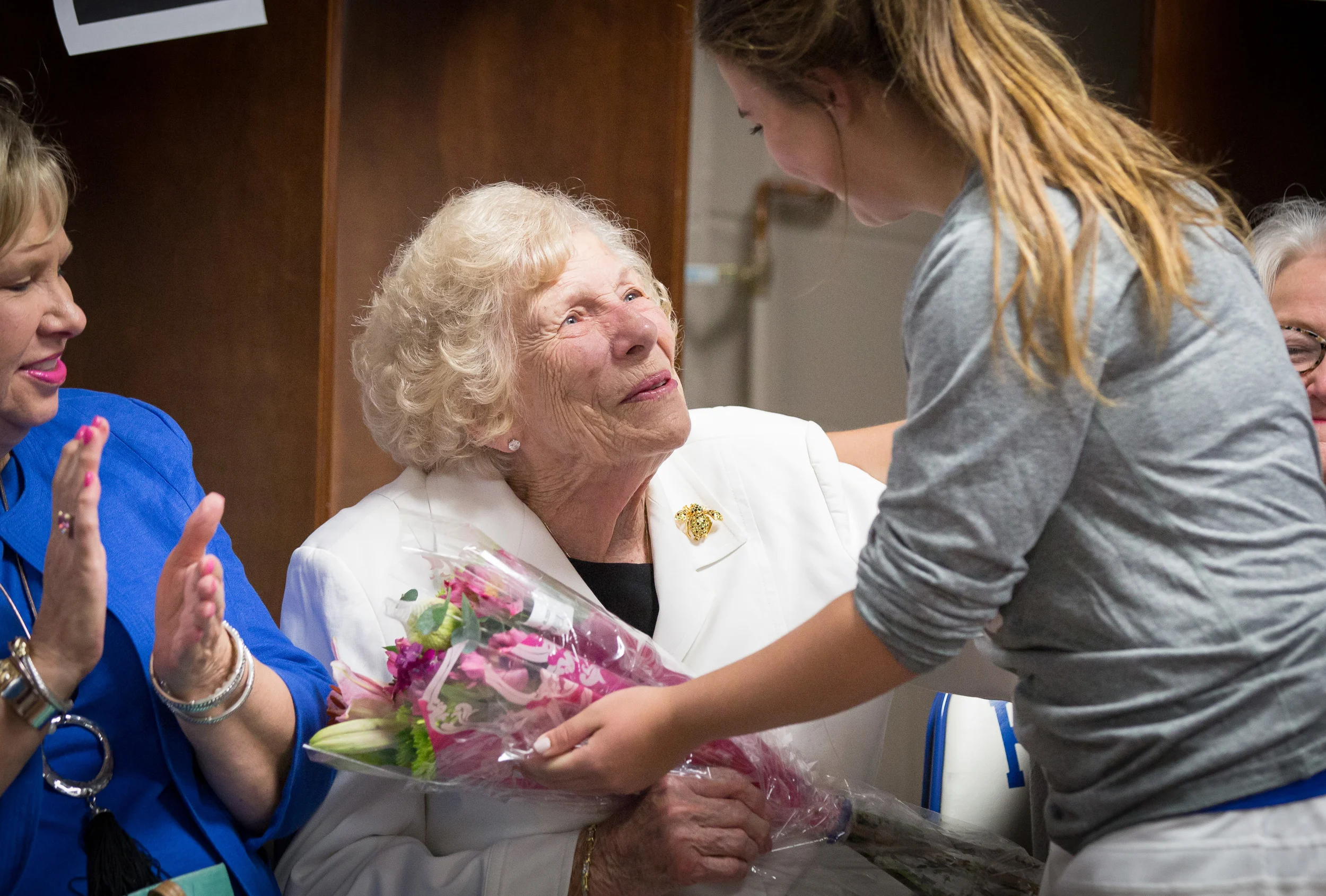 Mrs. Jewel Sisson receives flowers from her granddaughter, Caroline Sisson, who is one of many student-athletes who will benefit from the updates to our Cherry Road campus including the Lady Lions Locker Room.