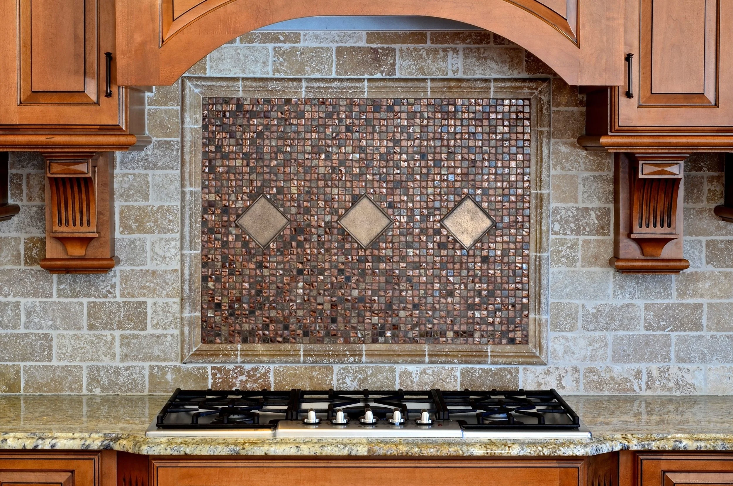 This beautiful mosaic and oiled bronze tile is an understated and elegant focal point in the cooking area. 