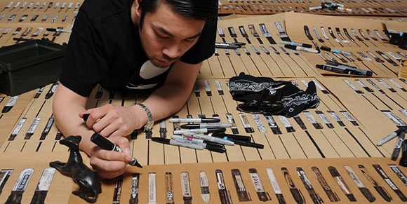 Allister Lee illustrating his massive collection of black markers.