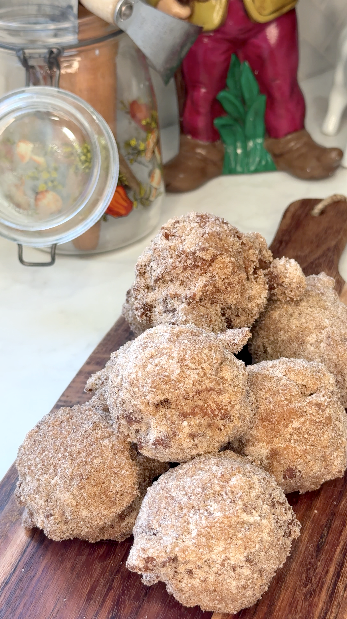 stack of homemade apple cider donut holes on a wooden serving board