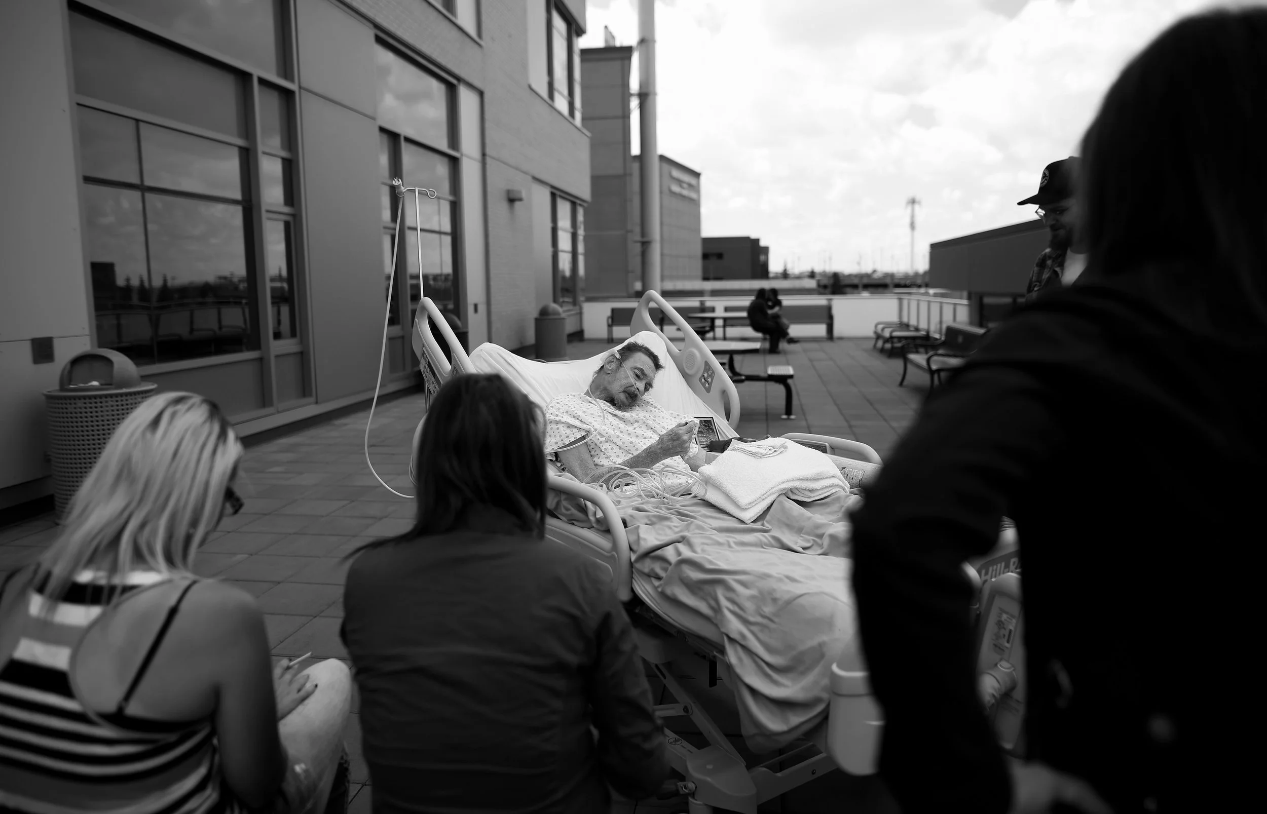 Surrounded by family and friends PJ McGrath enjoys a last smoke on the roof of the hospital where he has been the last ten months.