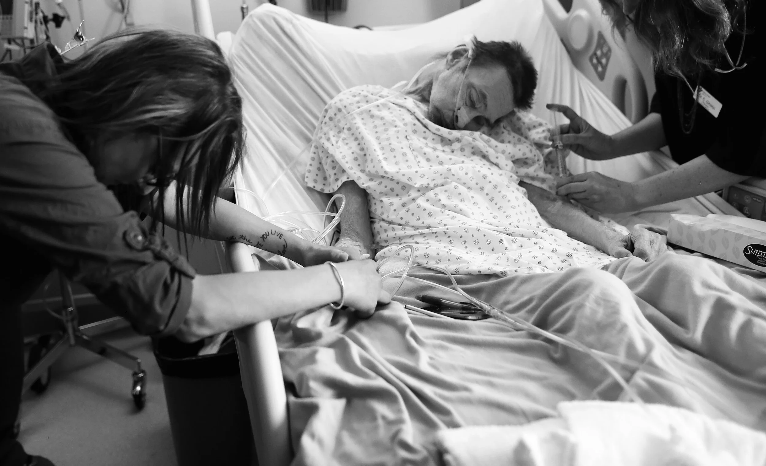 PJ McGrath's daughter comforts her dad as Dr. H administers medication during his assisted death in his hospital room.