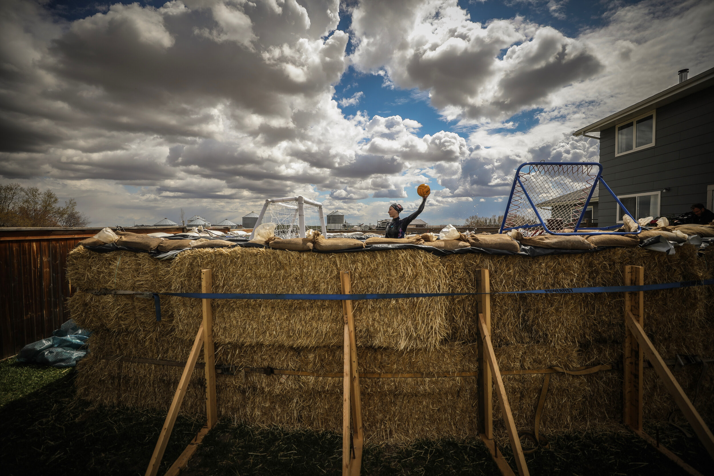  National water polo player Kyra Christmas trains in a pool made from hay bales on her family’s farm near Airdrie, Alberta, during the lockdown. 