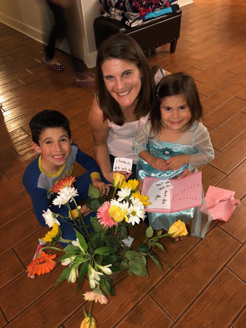 The beautiful bouquet takes center stage as Ana and Brandon give Auntie Lisa their card filled with homemade “gift certificates” (redeemable for foot rubs, “servant for a day”, etc.)