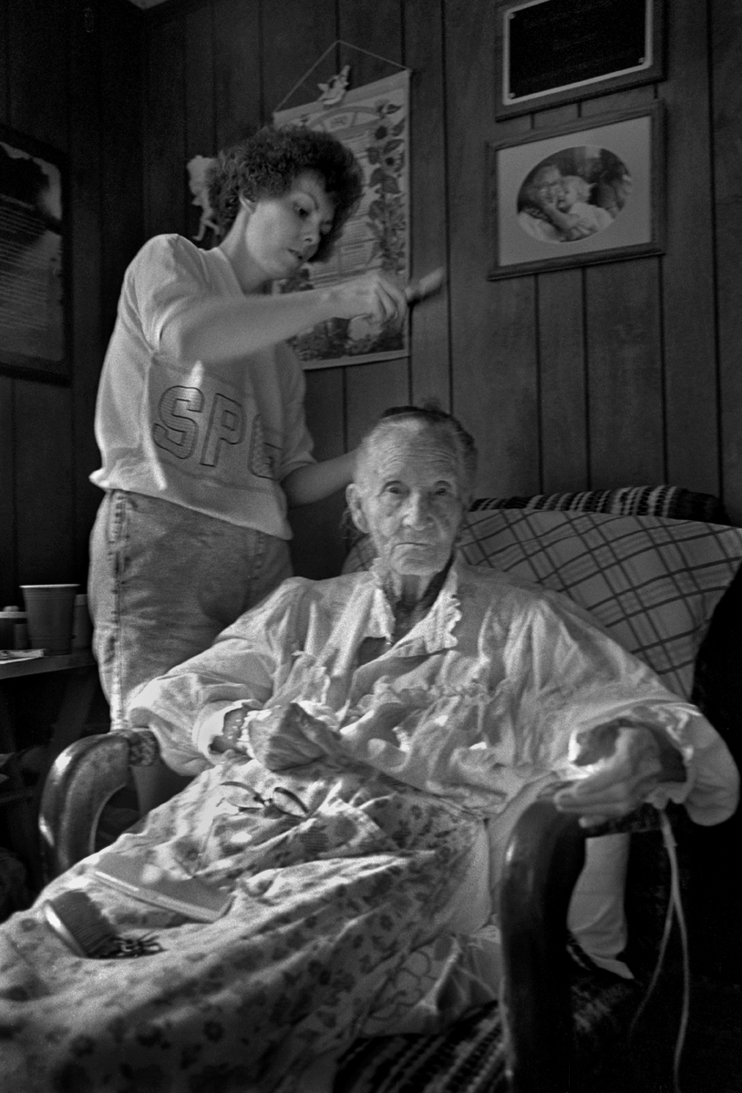Debbie Chandler brushing her grandmother's, Dellie Norton, hair, Sodom, Madison County, North Carolina, 1991