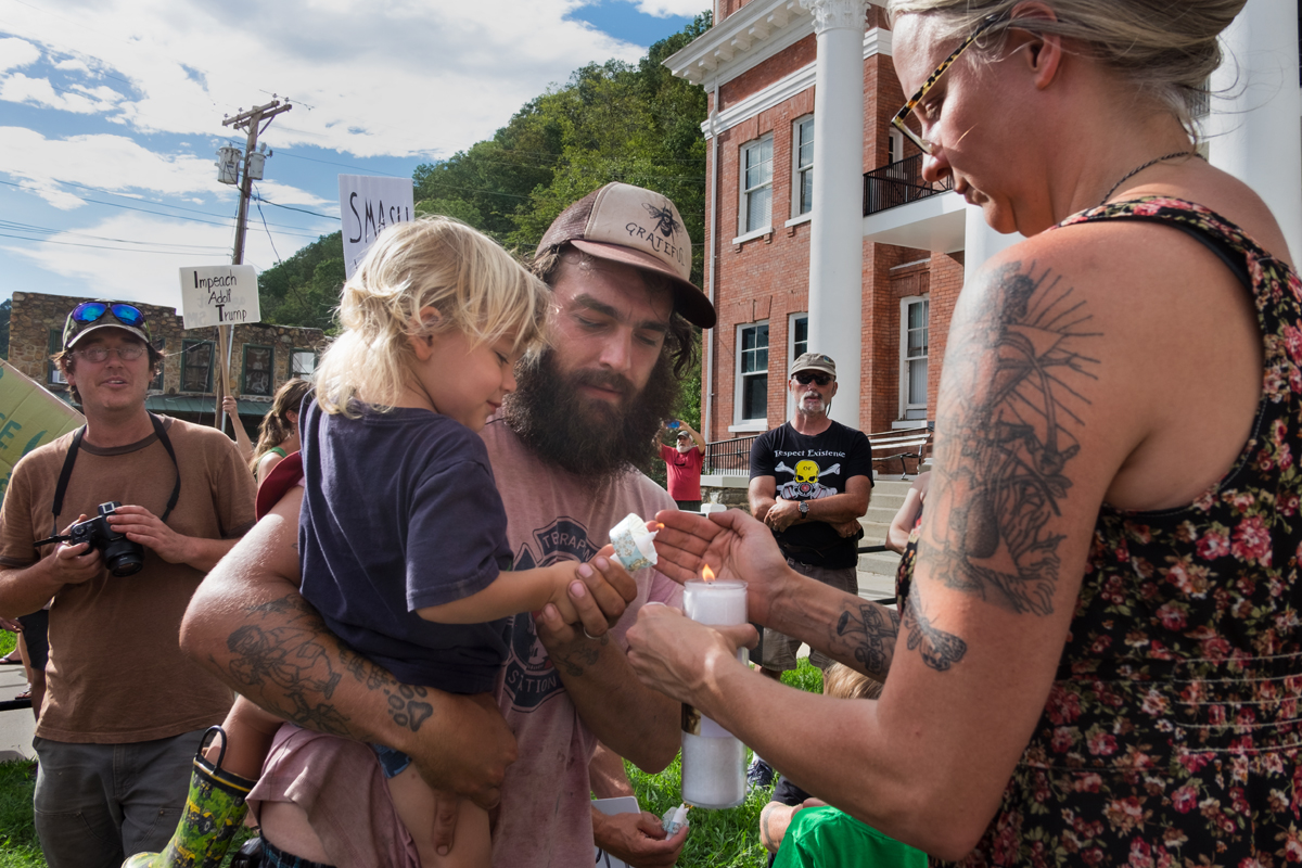Tommy Koloski and his son, Salix, light a candle for victims of racism at the anti-racism rally in downtown Marshall, North Carolina 2017.