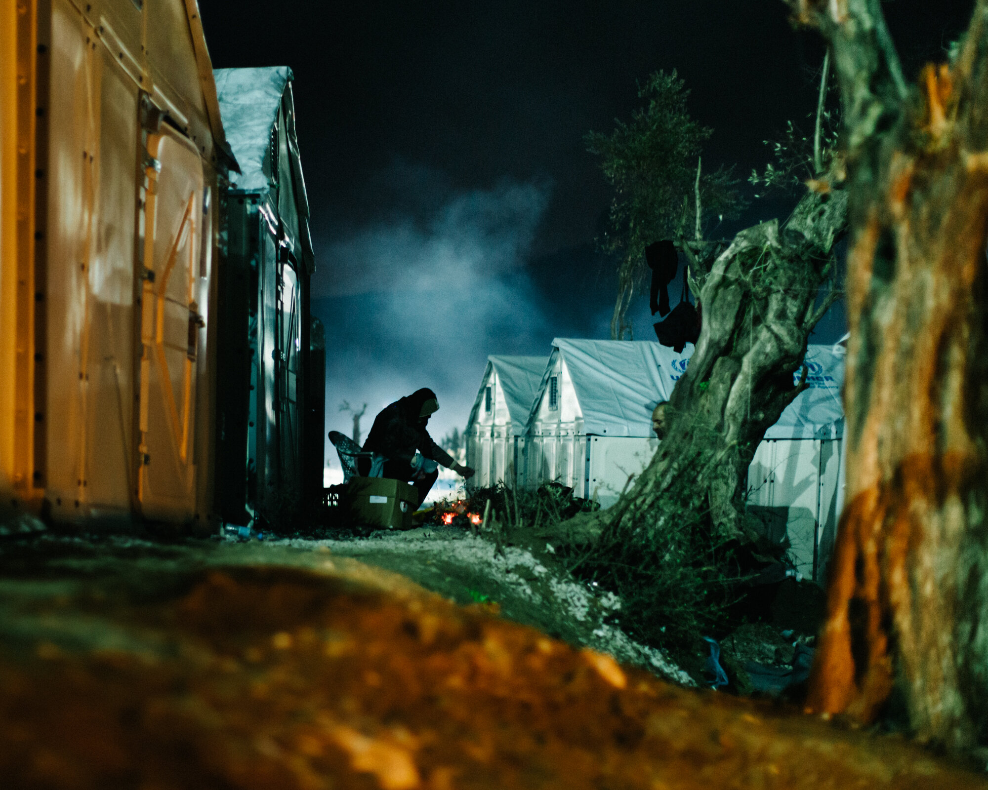  A man warms himself by a fire on a cold winter night in Moria.  