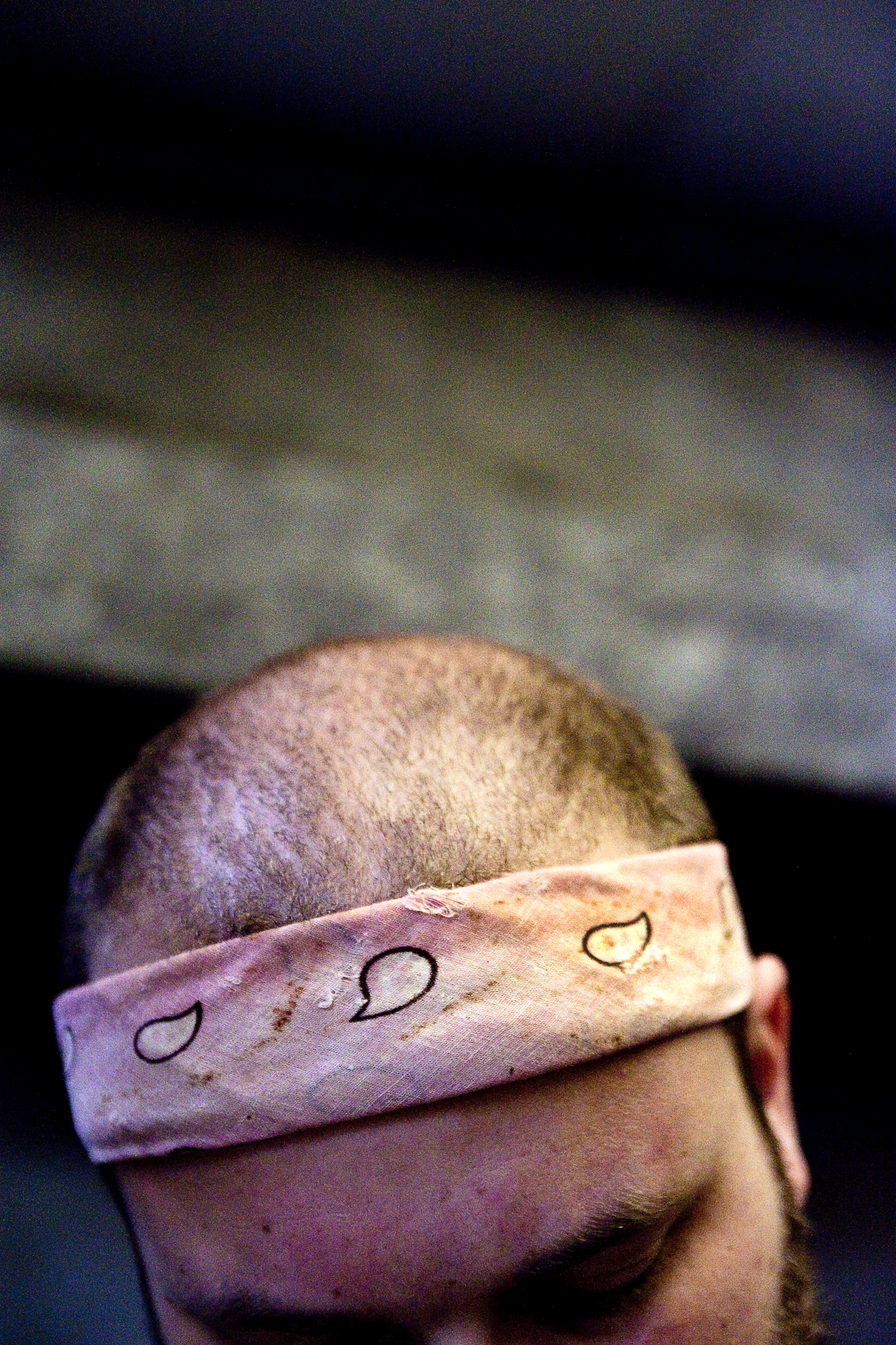 Vlasin wears a pink bandana while chopping green peppers. During performances, he wears a black bandana.