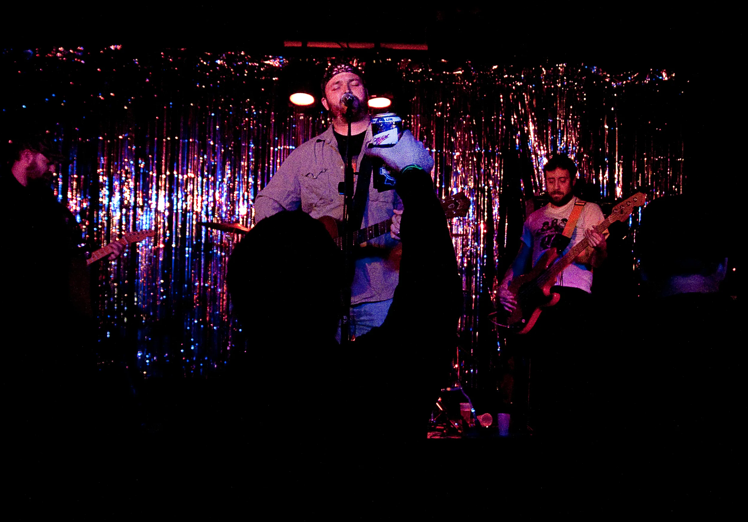 An audience member holds up a Miller High Life as Vlasin sings the song Friends In Bottles. "All my new friends live in bottles. Whiskey, wine and pills," he sings.