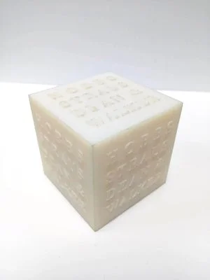 Branded cube 3D printed with glass-filled nylon using selective laser sintering (SLS).