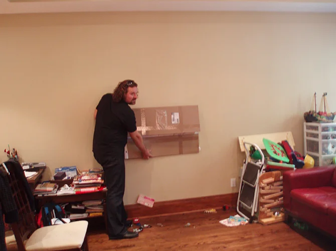 James Janz rearranging furniture in a client's home.
